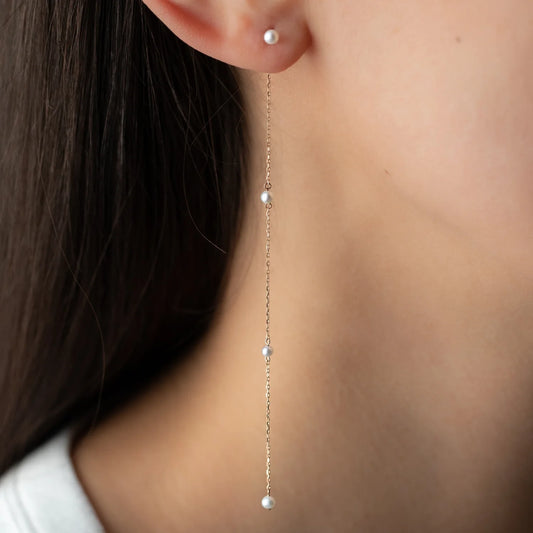 Anhänger ARIA in 18 KT Roségold mit drei weißen Perlen getragen an Ohr mit Ohrstecker Sea mini