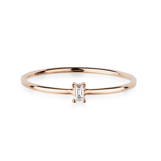 Eleganter Ring aus 18 KT Roségold gefertigt mit einem weißen Diamanten in Baguette-Schliff vertikal platziert auf der Ringschiene