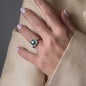 Hand mit Ring in weißgold mit grünen und weißen Diamanten in Bewegung