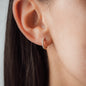 Ausschnitt von weiblichem Ohr mit diamantenbesetzten Goldschmuck im Ohr