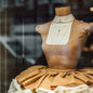 Nahaufnahme von ANNA Doll mit braunem Stoff in Schaufenster von ANNA Store