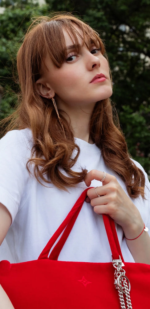 Frau mit roten Haaren und roter ANNA Friday Handtasche 