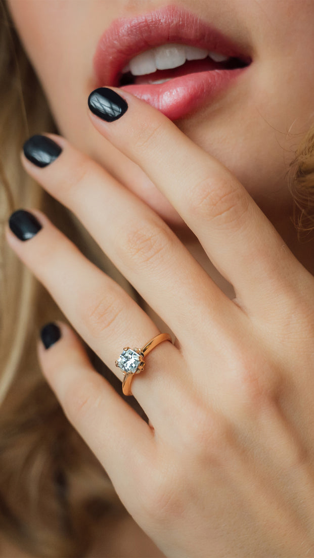Nahaufnahme von Frauen Hand mit Verlobungsring in 18 KT Roségold mit großem weißem Diamanten