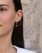 Anhänger Alice in 18 KT Rosegold mit einem Stern-Anhänger besetzt mit weißen Diamanten getragen an einer Kreole am Ohr