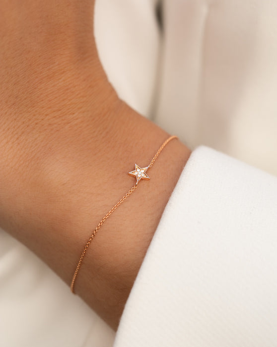 Filigrane Armkette in 18 KT Rosegold mit Stern-Anhaenger mit weißen Diamanten getragen an Handgelenk