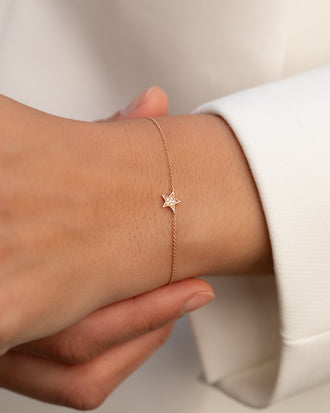 Filigrane Armkette in 18 KT Rosegold mit Anhaenger in Sternenform mit weißen Diamanten getragen an Handgelenk