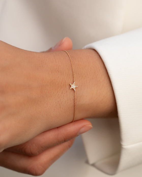 Filigrane Armkette in 18 KT Rosegold mit Anhaenger in Sternenform mit weißen Diamanten getragen an Handgelenk