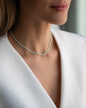 Kurze, blassgrüne Halskette mit Edelsteinen aus 18 KT Roségold. Halskette TAMI mit Chrysopras und Stern-Anhänger – ein sommerliches Schmuckstück von ANNA. Getragen am Hals einer Frau mit blonden Haaren und weißem Blazer.