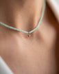 Kurze, blassgrüne Halskette mit Edelsteinen aus 18 KT Roségold. Halskette TAMI mit Chrysopras und Stern-Anhänger – ein sommerliches Schmuckstück von ANNA. Getragen am Hals einer Frau - Detailaufnahme.