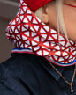 Rotes Seidentuch mit blau-weißem Muster als stilvolles Accessoire am Kopf getragen von einer blonden Frau.