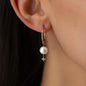 Nahaufnahme von Anhänger DEMI für Ohrringe in Roségold mit großer weißer Perle und Anna Stern getragen an Ohrring von Frau