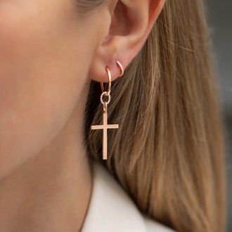 Nahaufnahme Ohr von blonder Frau mit Kreole und ANNA Anhänger TOMMY mit Kreuz Symbol und weißen Diamanten in 18 KT Roségold