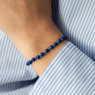 Nahaufnahmem von Armband ELLIOT mit 18 KT Roségold Verschluss und blauen Lapislazuli Perlen getragen an Handgelenk von Frau 
