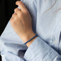 Arm von Frau in blau-weiß gestreifter Bluse mit Armband ELLIOT mit Lapislazuli Edelsteinen und Diamantring
