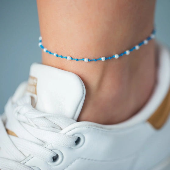Fußband MALIBU in Blau mit weißen Perlen getragen an Fußgelenk