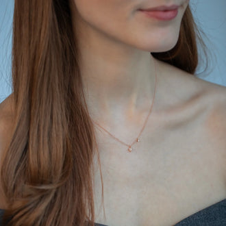 Frau mit roten Haaren und zarter ANNA Halskette in 18 KT Roségold mit zwei runden Diamanten
