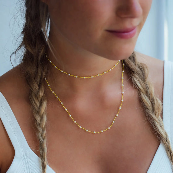 Halskette RIO mit gelben Stoffband mit weißen Perlen getragen