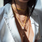 Hals von Frau mit Halskette Rio in Sonnengelb und vielen Halsketten in 18 KT Roségold