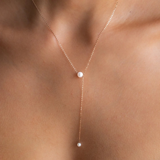 Nahaufnahme von Halskette SADIE in 18 KT Roségold mit zwei 6mm großen Akoya-Perlen getragen um Hals von Frau