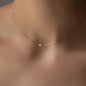 Nahaufnahme von Halskette SEA MINI in Roségold mit weißer kleiner Perle getragen an Hals von Frau