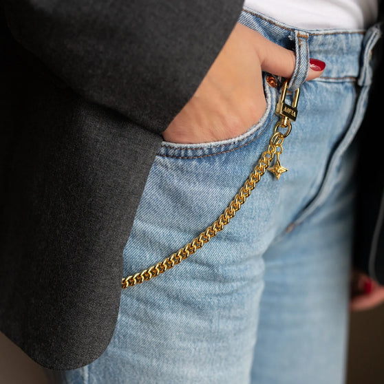 Goldene Schlüsselkette mit ANNA Logo Prägung und ANNA SIgnature Star getragen an Hose von Frau