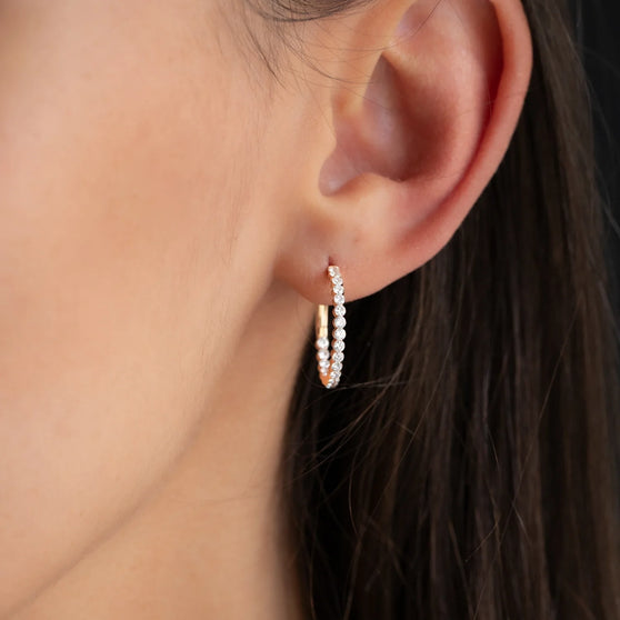 Nahaufnahme von Diamantkreole CHLOE mit 20mm Durchmesser in 18 KT Roségold getragen an Ohr von Frau