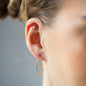 Ear Piercing Ariel in Sternform, mit weißen Diamanten und in 18 KT Rosegold getragen an Ohr von Frau