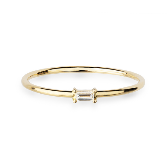 Eleganter Ring aus 18 KT Gelbgold gefertigt mit einem weißen Diamanten in Baguette-Schliff horizontal platziert auf der Ringschiene