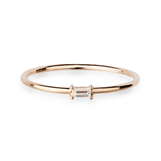 Eleganter Ring aus 18 KT Roségold gefertigt mit einem weißen Diamanten in Baguette-Schliff horizontal platziert auf der Ringschiene