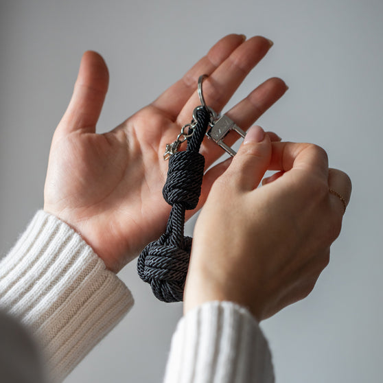 Schlüsselanhänger ROBBIE in Schwarz in Hand von Frau
