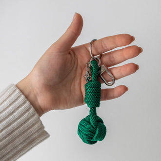 Schlüsselanhänger ROBBIE in Grün in Hand von Frau