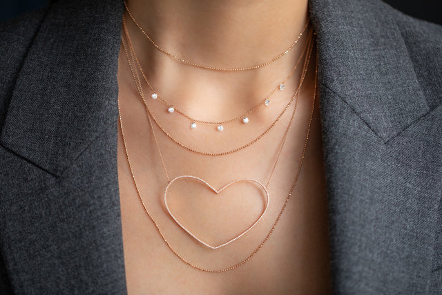 Frau mit Halsketten Layering in 18 KT Roségold mit Diamanten und Herz-Anhänger