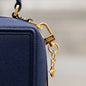 Nahaufnahme von Handtasche ELLEN in Midnight Blue und Taschenanhänger ANNA Signature Star in Gelbgold