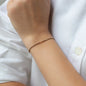 Armband KAI mit beigem Stoffband und drei Perlen aus 18 KT Roségold getragen an Handgelenk