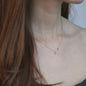 Frau in Bewegung mit roten Haaren und zarter Diamantkette in 18 KT Rosegold
