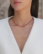Kurze, rote Halskette mit Edelsteinen aus 18 KT Roségold. Halskette mit Karneolen und Türkisen – ein sommerliches Schmuckstück von ANNA. Getragen am Hals einer Frau mit schwarzen Haaren und weißem Blazer.