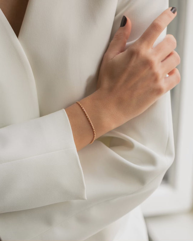 Zarte und filigrane Armkette aus Roségold mit einem grossen Herzanhänger. Getragen an einem Frauenhandgelenk.