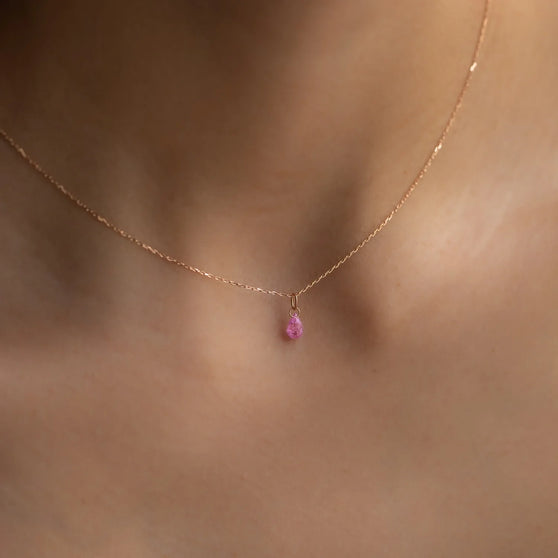 Nahaufnahme von Anhänger Roxy in Roségold mit pinkem Saphir getragen an feiner Halskette von Frau