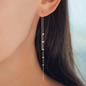 Detailaufnahme von Frau mit roségoldenem Ketten Ohrring und Diamanten