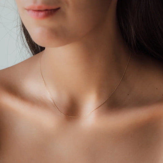 Ausschnitt von Frau mit kurzer Halskette in Gelbgold 