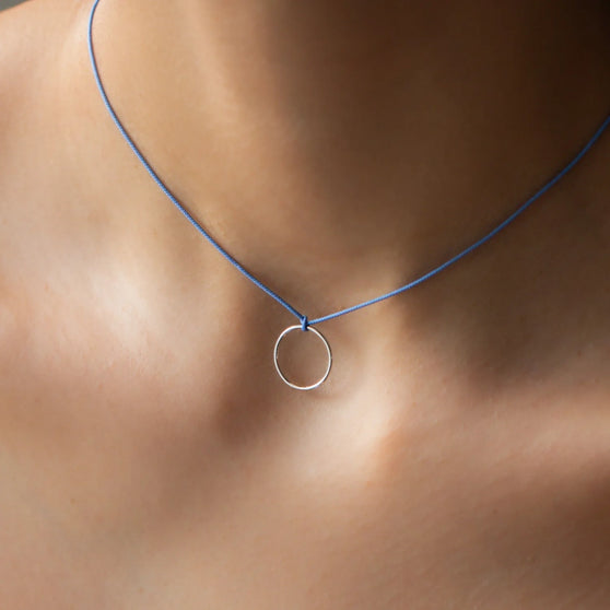 Dekolleté von Frau mit kurzer Halskette LEXI mit Silber Anhänger und blauem Stoffband