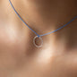 Nahaufnahme von Halskette LEXI mit rundem Silberanhänger und blauem Stoffband getragen von Frau