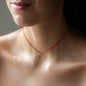 Dekolleté von Frau mit kurzer Halskette LEXI mit Silber Anhänger und rotem Stoffband