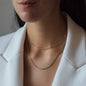 Halskette NALA mit Grünen Details in Roségold getragen von Frau in weißem Blazer