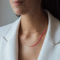Halskette NALA mit pinken Details in Roségold getragen von Frau in weißem Blazer, doppelt getragen