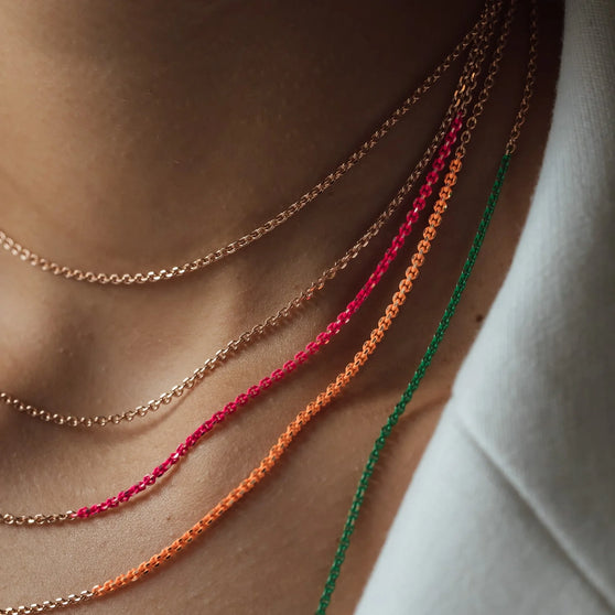 Halsketten NALA in Roségold mit pinken, orangenen und grünen details getragen von Frau