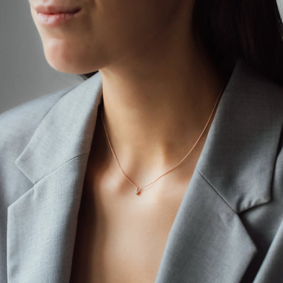 Halskette SOUL mit weißem Diamant in Roségold getragen von Frau in grauem Blazer