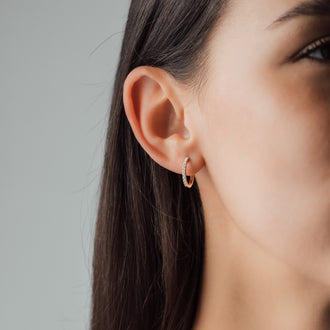 Auschnitt von Frauengesicht mit Kreolen Ohrring 15 mm in Rosegold mit weiße Diamanten