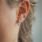 Ohr mit Ohrring Jolie in Weißgold mit weißen Diamanten und 15mm Durchmesser getragen von blonder Frau