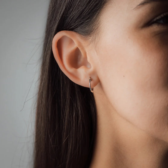 Gesichtsausschnitt von Frau mit silbernem Ohrring Kreole Mara 15mm